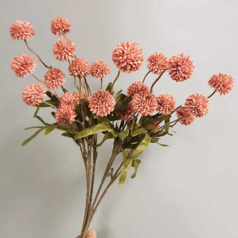 Close-up of pink artificial dandelion flowers in decorative vase